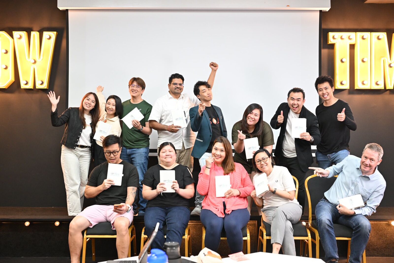 Workshop participants holding their completed workbooks